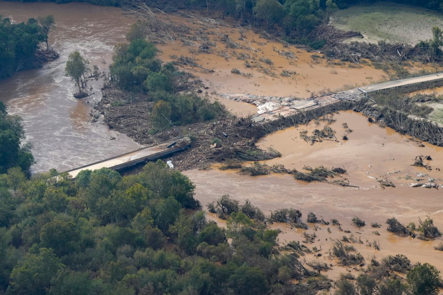 An aerial view a damaged bridge and flooding in the aftermath of Hurricane Helene is seen along the Nolichucky River, Saturday, Sept. 28, 2024, in Greene County, Tenn. (AP Photo/George Walker IV)