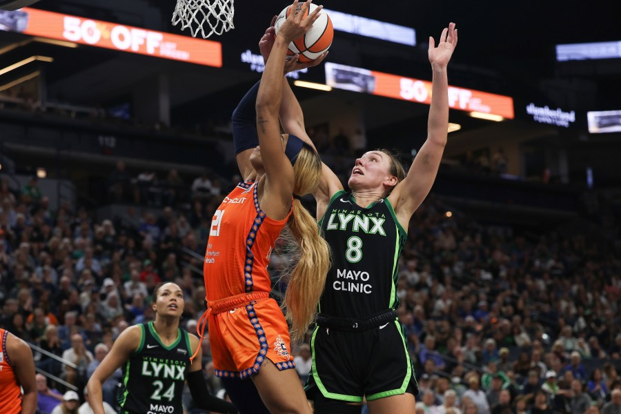 Minnesota Lynx forward Alanna Smith (8) blocks a shot by Connecticut Sun guard DiJonai Carrington (21) during the second half of Game 1 of a WNBA basketball semifinals series Sunday, Sept. 29, 2024, in Minneapolis. (AP Photo/Stacy Bengs)