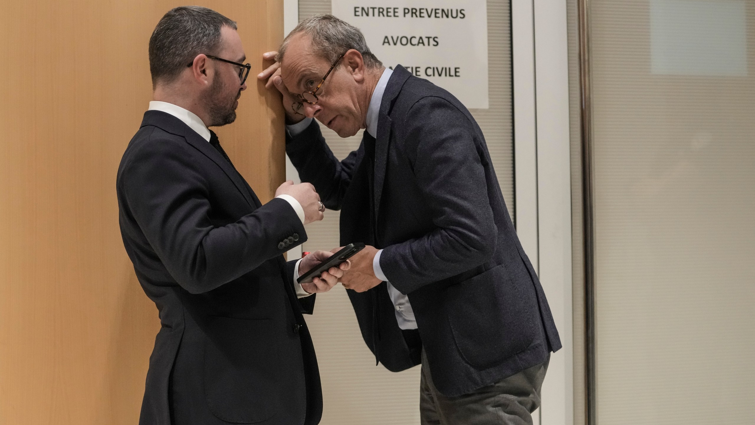 Member of the French far right party Alexandre Varaut, left, talks to an unidentified person at the court house in Paris, Monday, Sept. 30, 2024. (AP Photo/Thibault Camus)