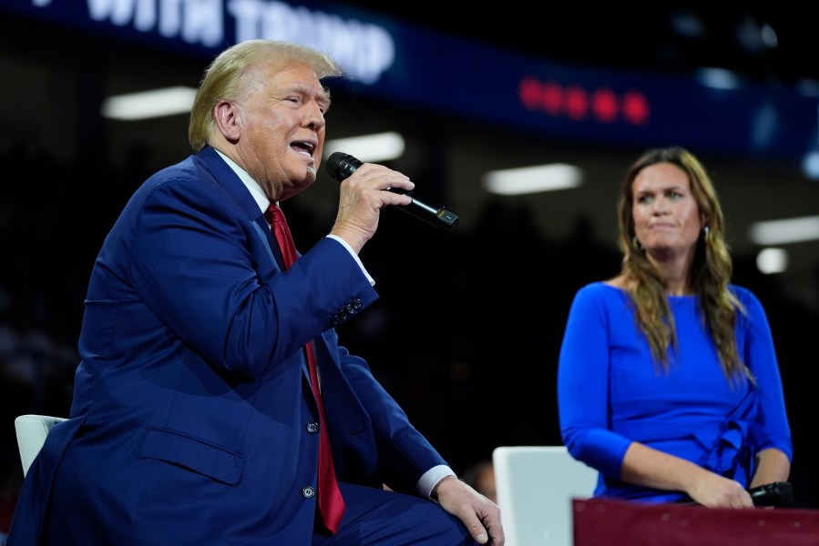 Republican presidential candidate former President Donald Trump, left, on stage with Arkansas Gov. Sarah Huckabee Sanders.