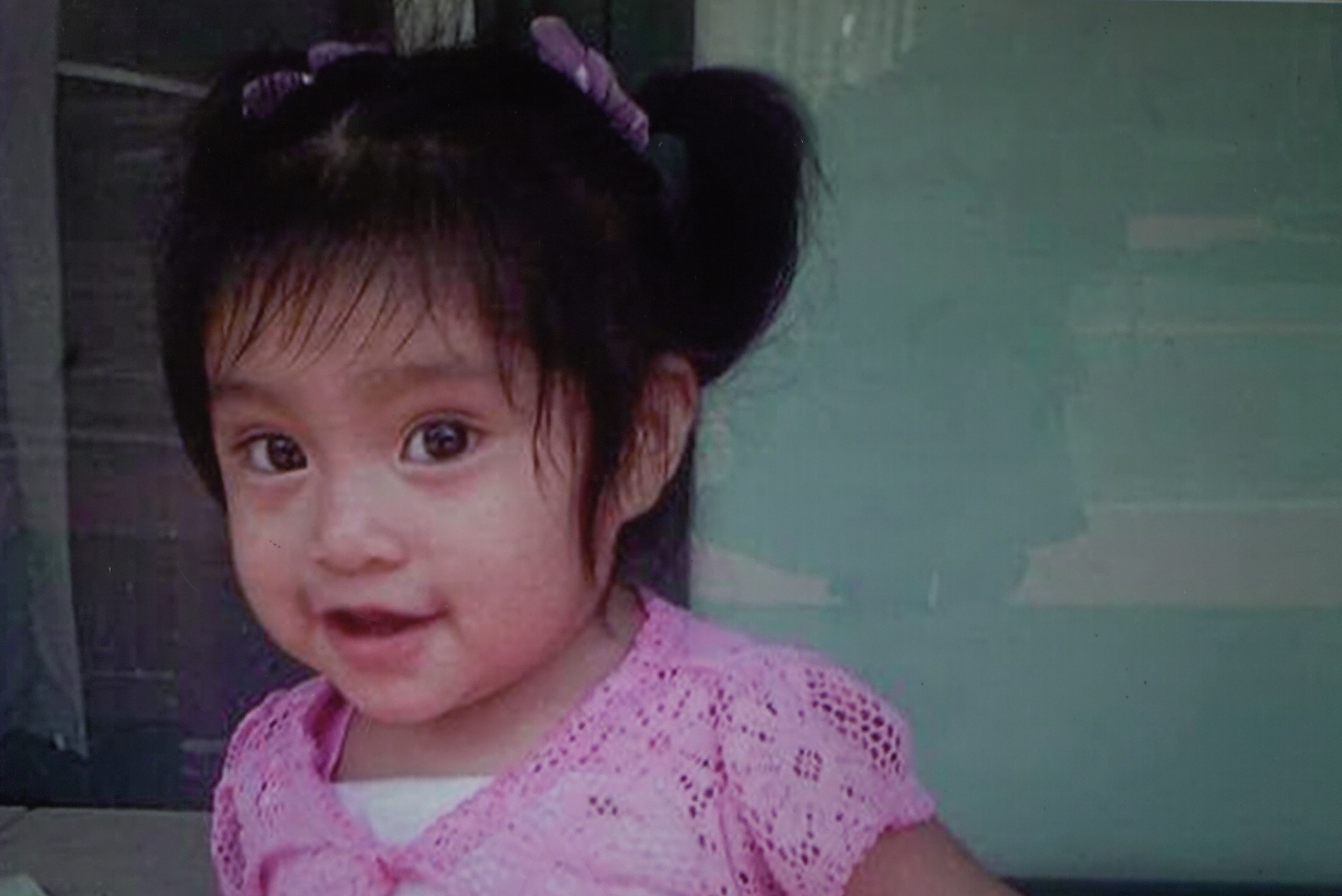 A photo of a toddler-aged girl with dark hair and eyes.