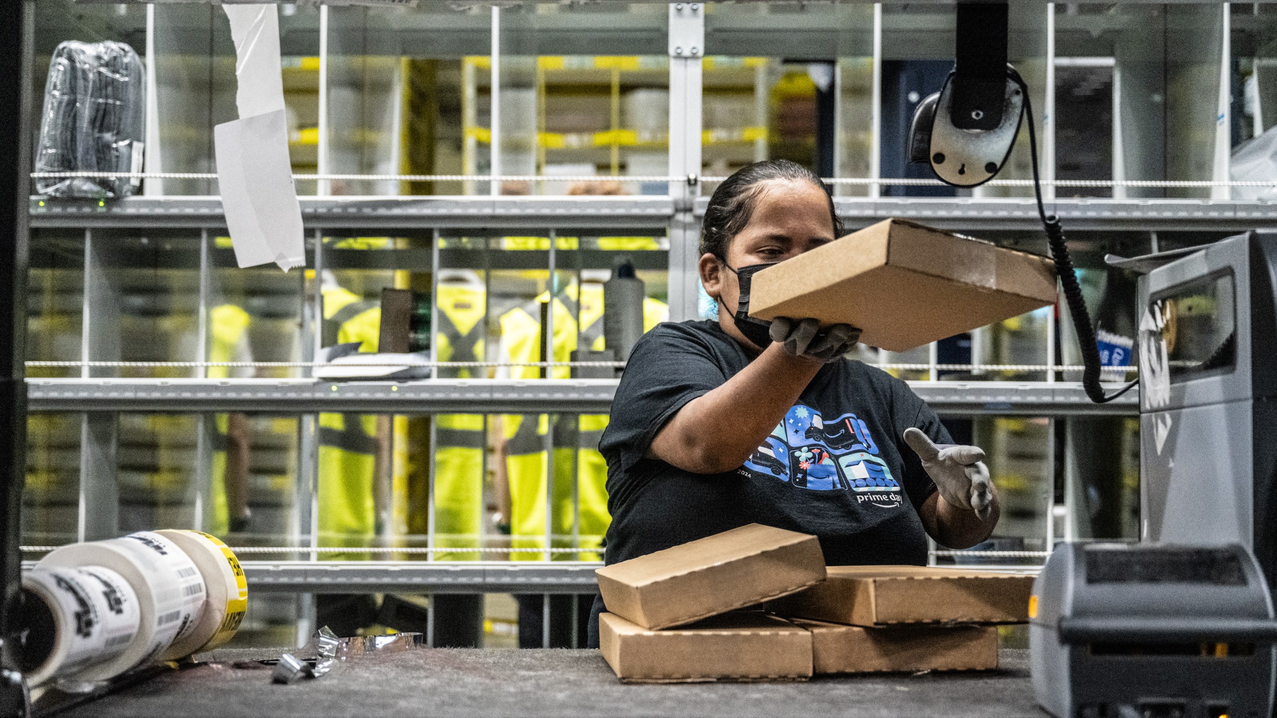 A worker prepares packages at an Amazon same-day delivery fulfillment center.