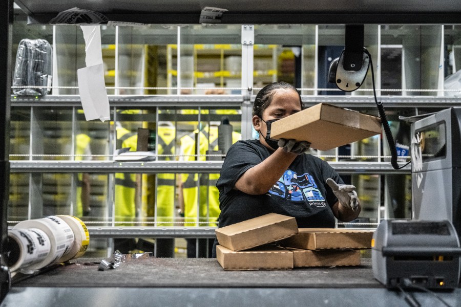 A worker prepares packages at an Amazon same-day delivery fulfillment center.