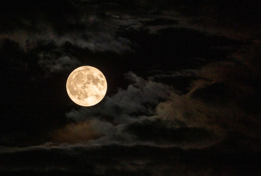 A supermoon cuts through the clouds.