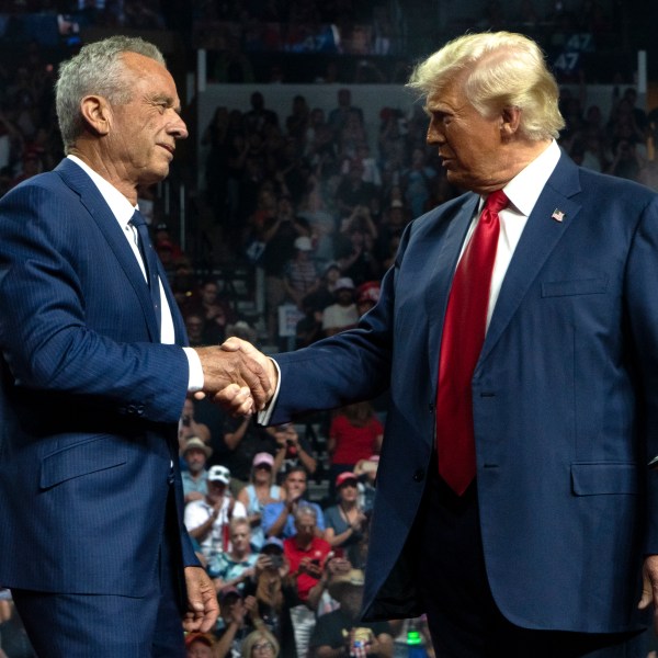 Former Republican presidential candidate Robert F. Kennedy Jr. and Republican presidential nominee, former U.S. President Donald Trump shake hands during a campaign rally at Desert Diamond Arena on August 23, 2024