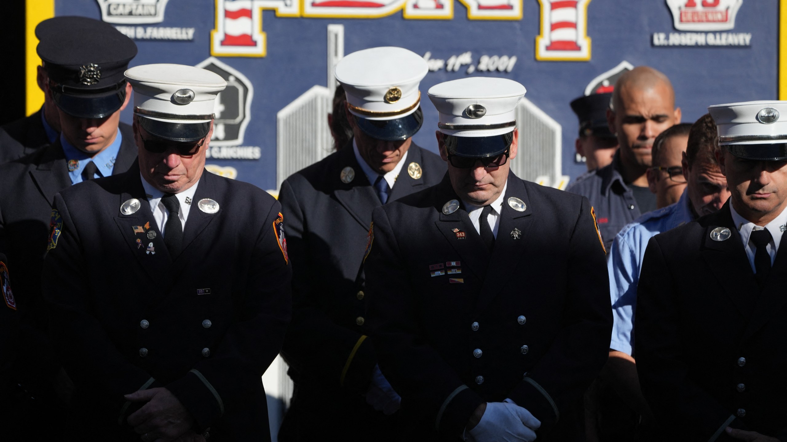 Firefighters pause for a second moment of silence outside FDNY Engine 4/Ladder 15's firehouse in lower Manhattan on the 23rd anniversary of the 9/11 terrorist attacks in 2001, on September 11, 2024 in New York.