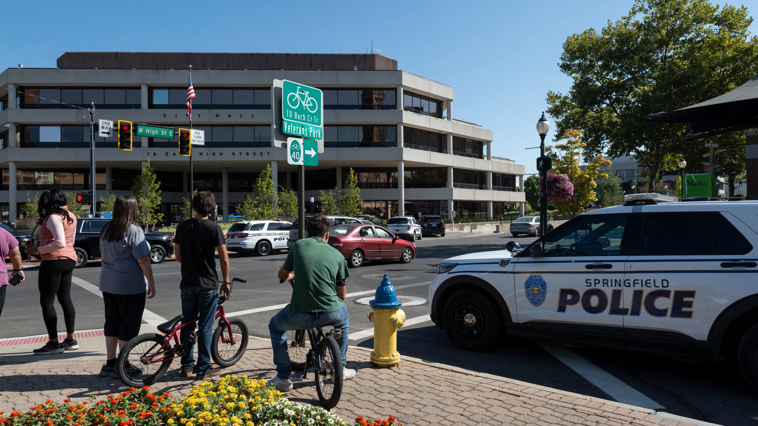 People watch as Springfield Police Department officers investigate the Springfield City Hall after bomb threats were made.