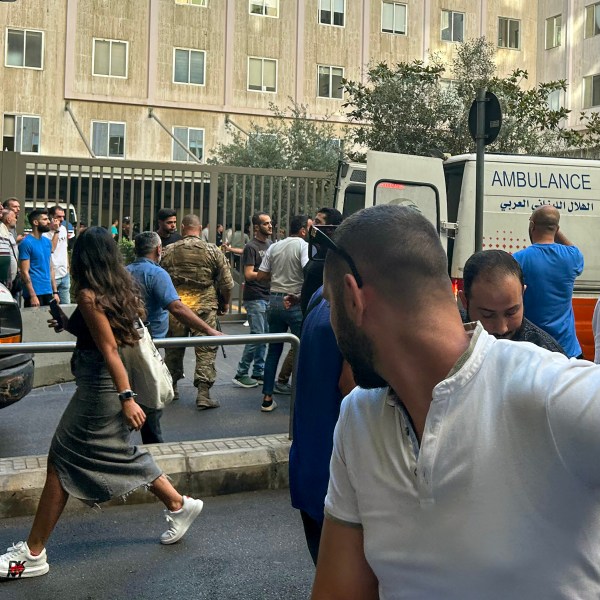 People in Lebanon look on as ambulances arrive.