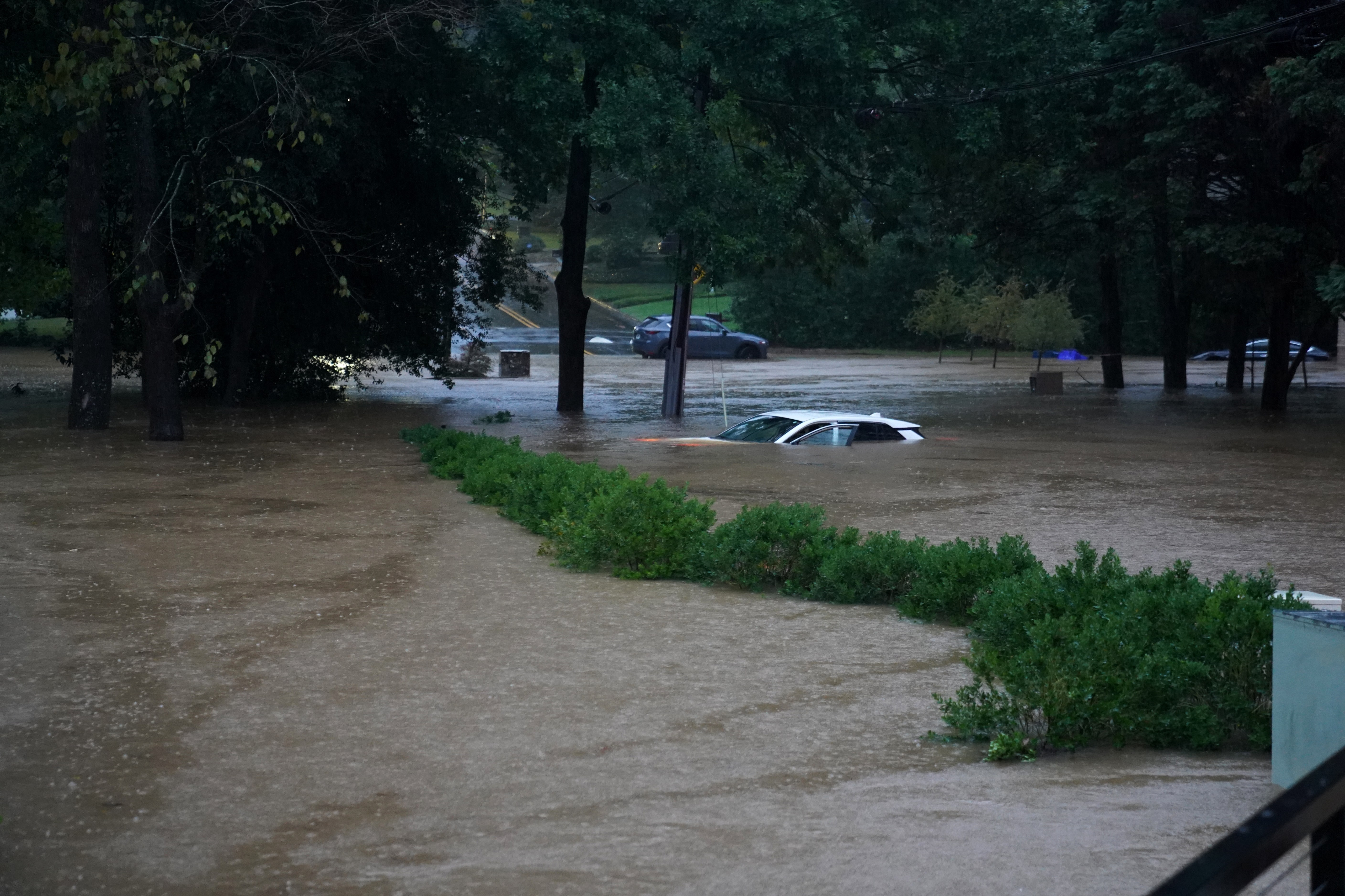 Flooded areas in Georgia including a car with only the roof visible.