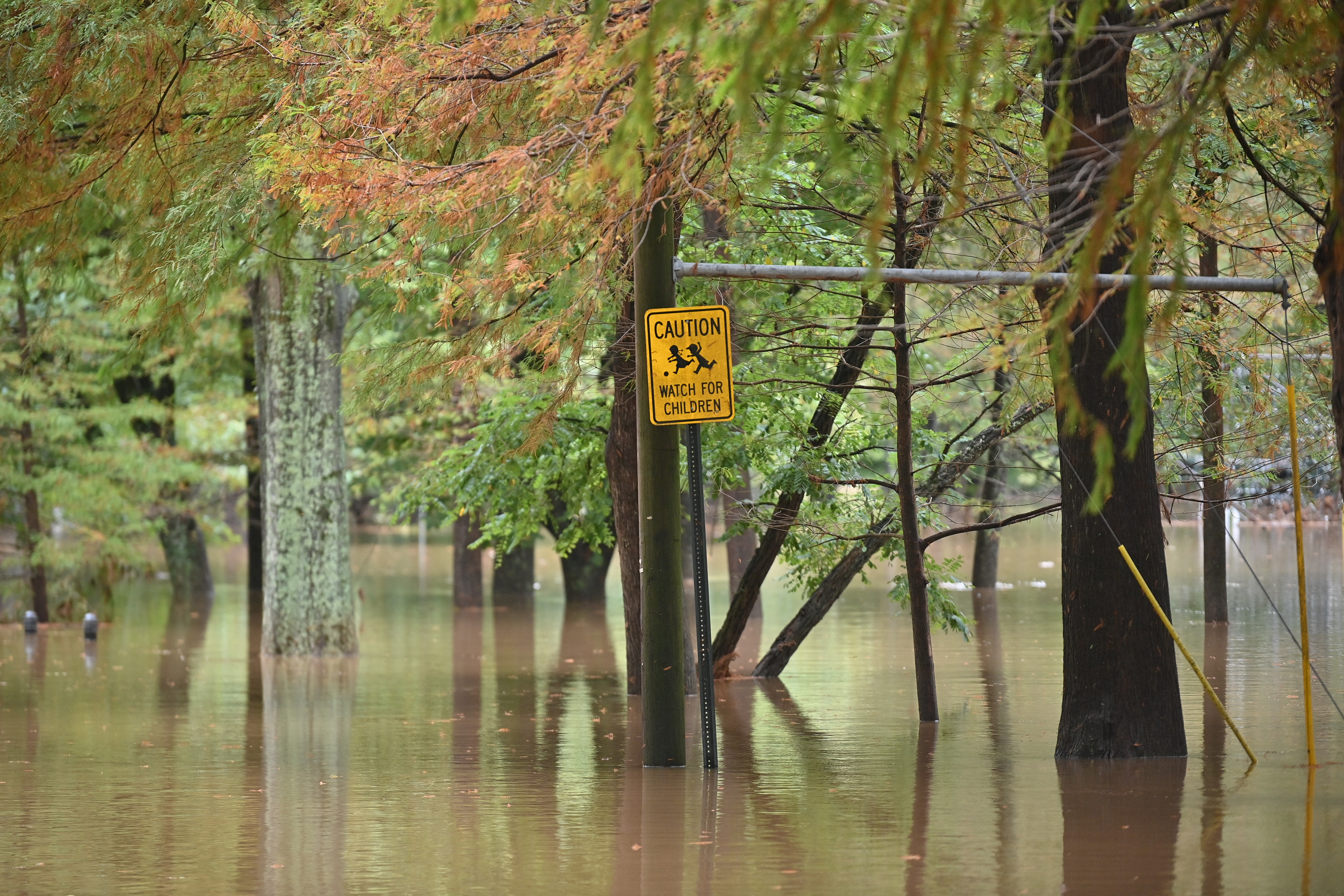 A "watch for children" sign is seen on a flooded street after Hurricane Helene made landfall in Atlanta, Georgia, on September 27, 2024.