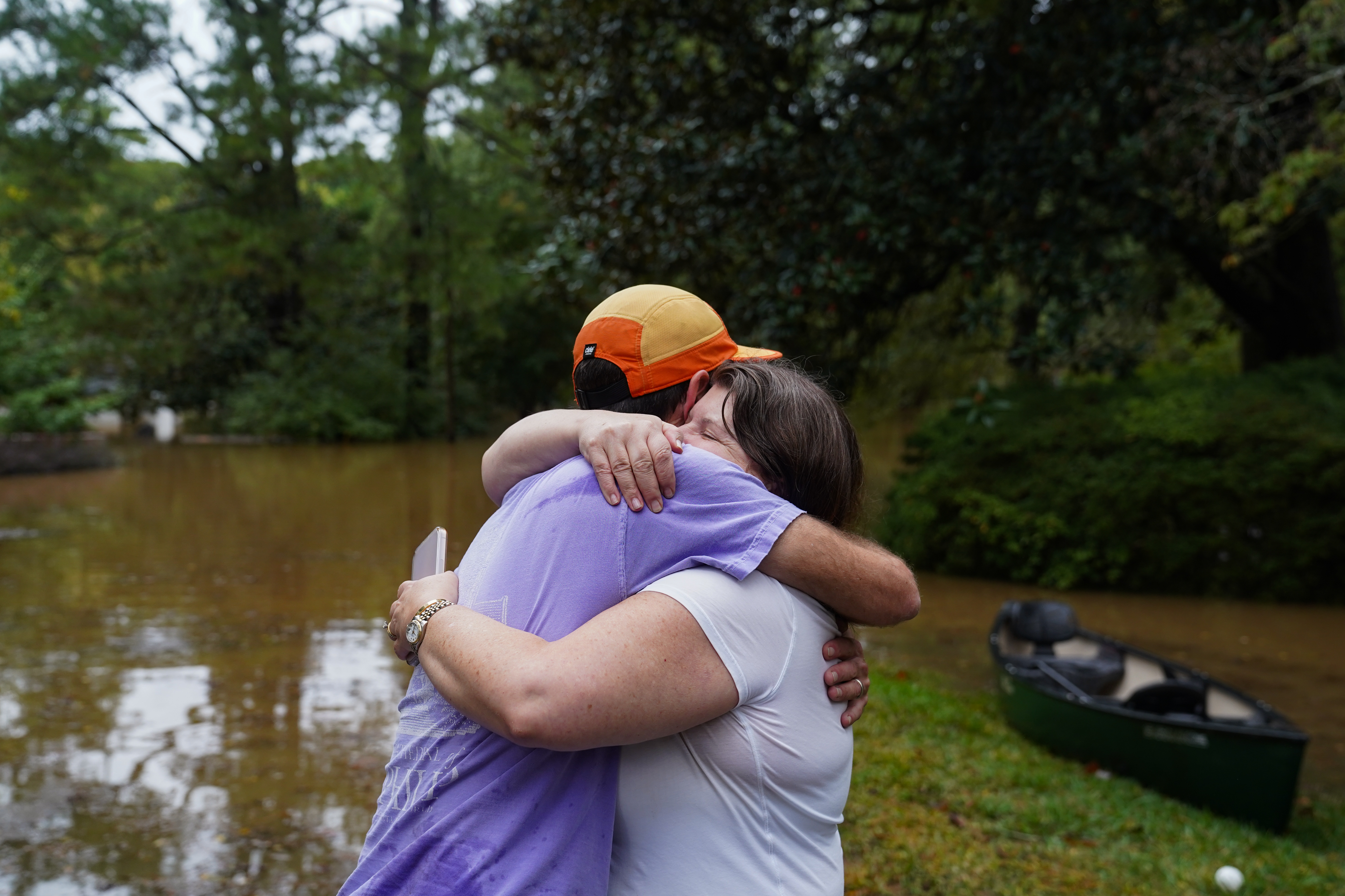 Dan Murphy hugs his colleague after bringing his canoe to rescue them from their flooded home as the streets are flooded near Peachtree Creek after hurricane Helene brought in heavy rains overnight on September 27, 2024 in Atlanta, Georgia.