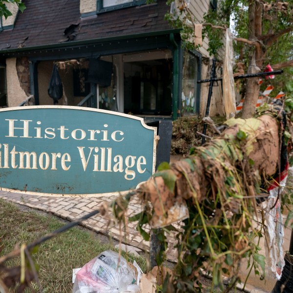 A sign for Biltmore village surrounded by debris