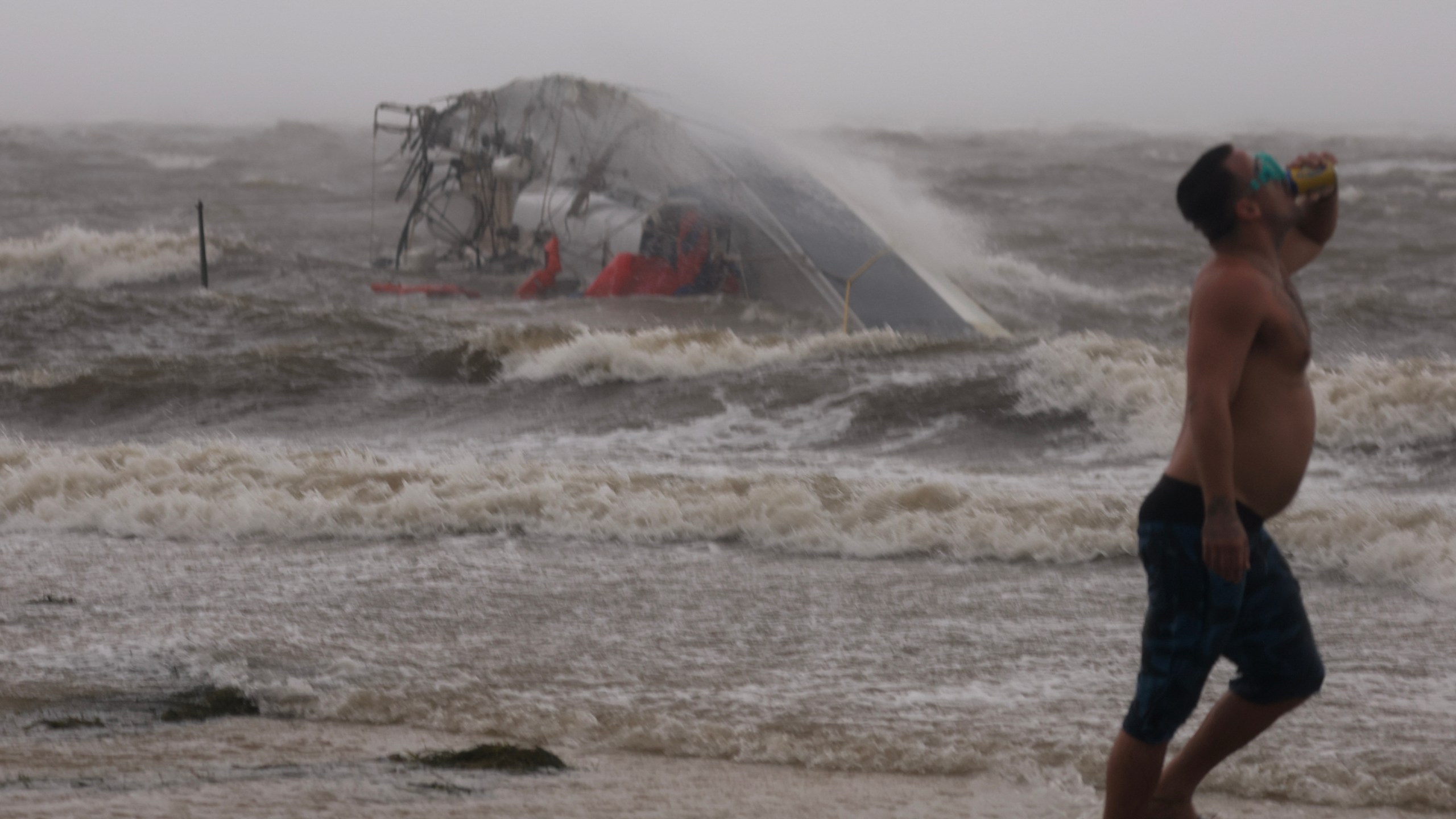 A capsized boat washes ashore as Hurricane Helene churns offshore on September 26, 2024 in St. Peteersburg Florida.