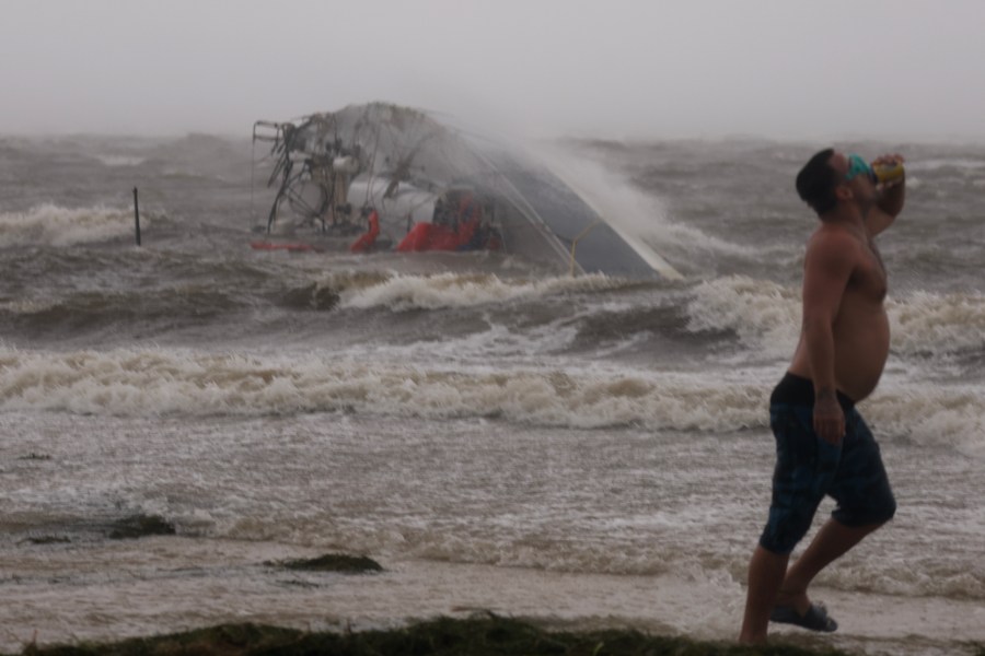 A capsized boat washes ashore as Hurricane Helene churns offshore on September 26, 2024 in St. Peteersburg Florida.