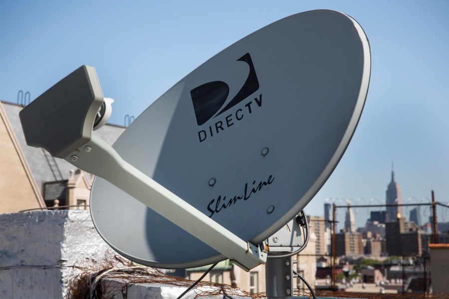 A DirecTV satellite dish sits on a roof in New York City.