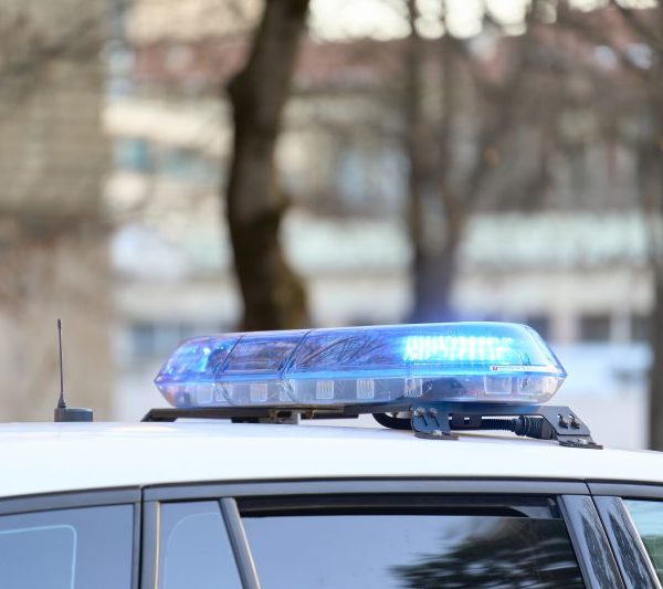 A close-up view of a police vehicle with the windows and doors closed.