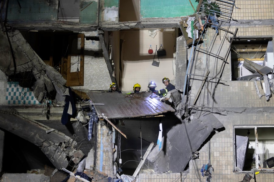 Rescue workers clear the rubble inside a building damaged by a Russian airstrike in Kharkiv, Ukraine, Thursday Oct. 3, 2024. (AP Photo/Yevhen Titov)