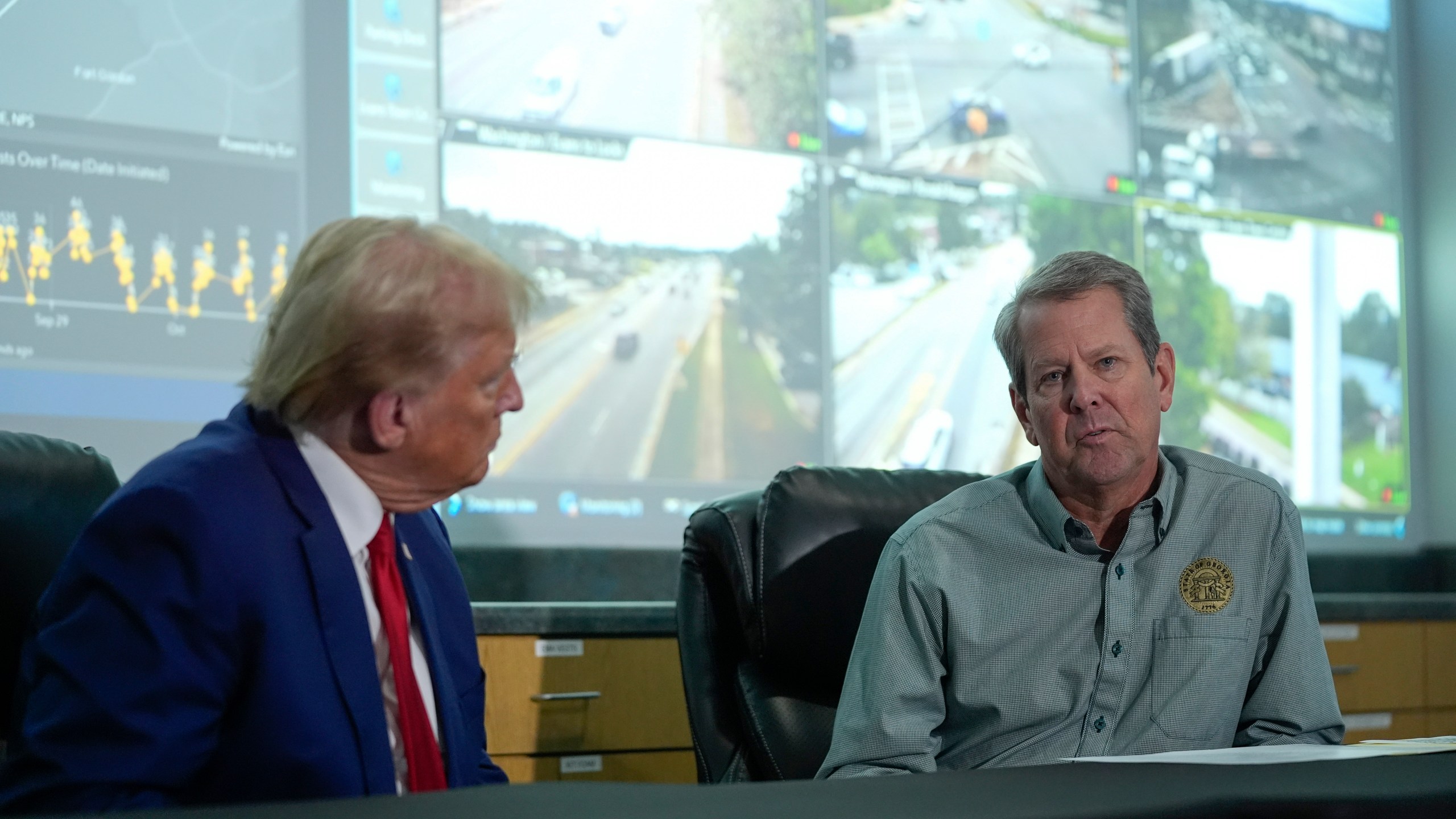 Republican presidential nominee former President Donald Trump talks with Georgia Gov. Brian Kemp during a briefing at the Columbia County Emergency Management Agency as he visits areas impacted by Hurricane Helene, Friday, Oct. 4, 2024, in Evans, Ga. (AP Photo/Evan Vucci)