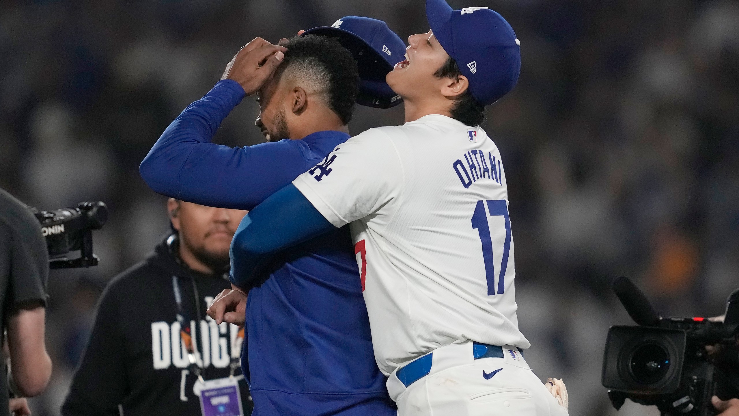 Los Angeles Dodgers' Shohei Ohtani, right, hugs Teoscar Hernández after the Dodgers defeated the San Diego Padres in Game 1 of baseball's NL Division Series, Saturday, Oct. 5, 2024, in Los Angeles. (AP Photo/Ashley Landis)