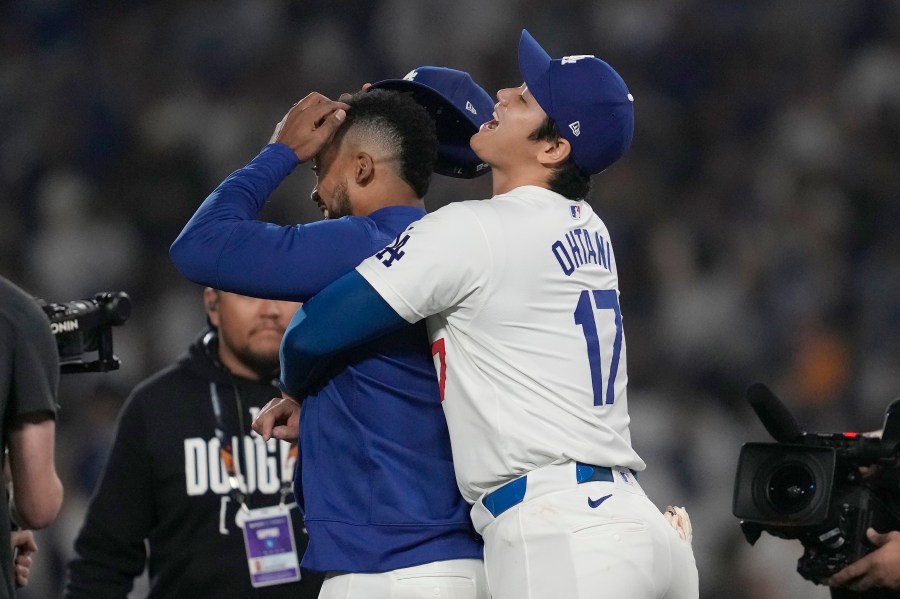 Los Angeles Dodgers' Shohei Ohtani, right, hugs Teoscar Hernández after the Dodgers defeated the San Diego Padres in Game 1 of baseball's NL Division Series, Saturday, Oct. 5, 2024, in Los Angeles. (AP Photo/Ashley Landis)