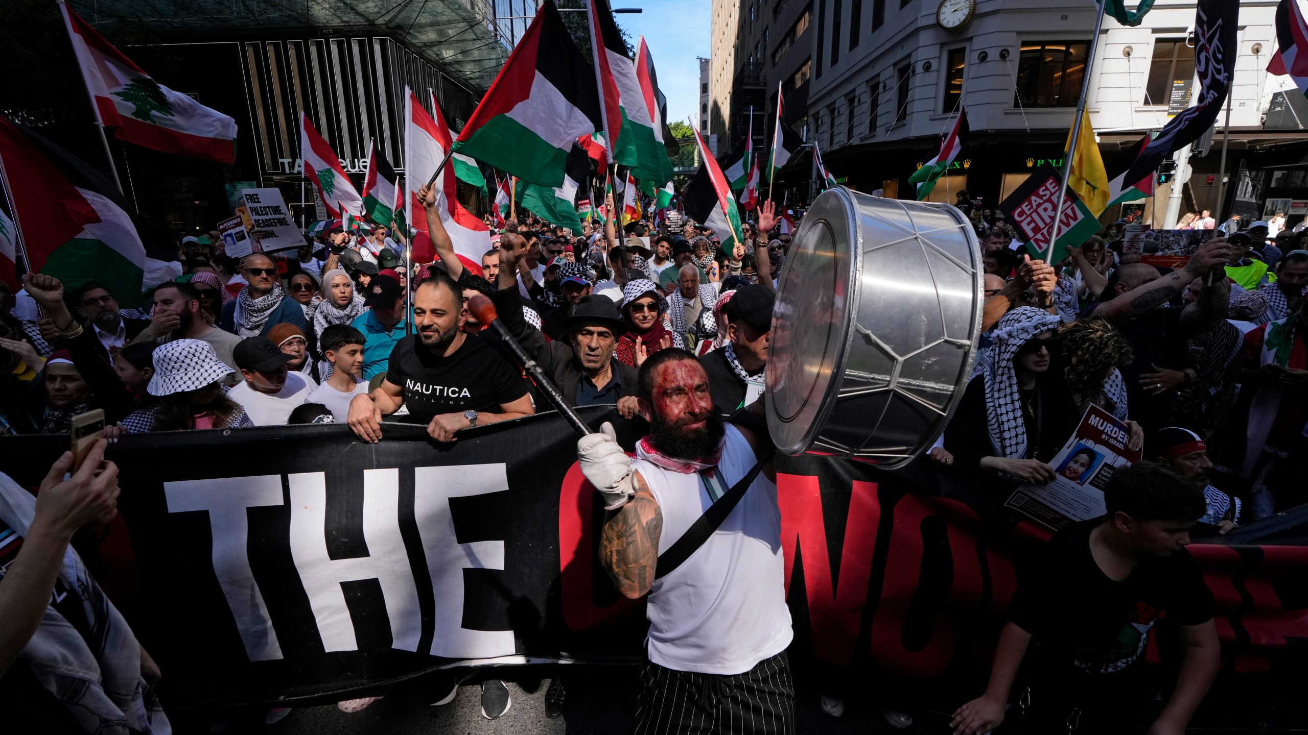 A man bangs a drum during a march as pro-Palestinian supporters rally in Sydney, Sunday, Oct. 6, 2024. (AP Photo/Rick Rycroft)