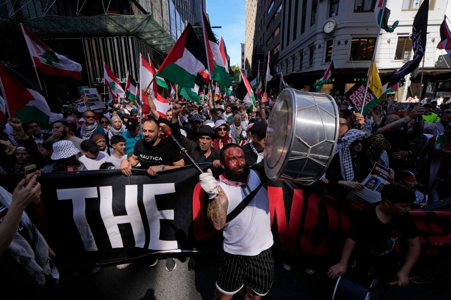 A man bangs a drum during a march as pro-Palestinian supporters rally in Sydney, Sunday, Oct. 6, 2024. (AP Photo/Rick Rycroft)