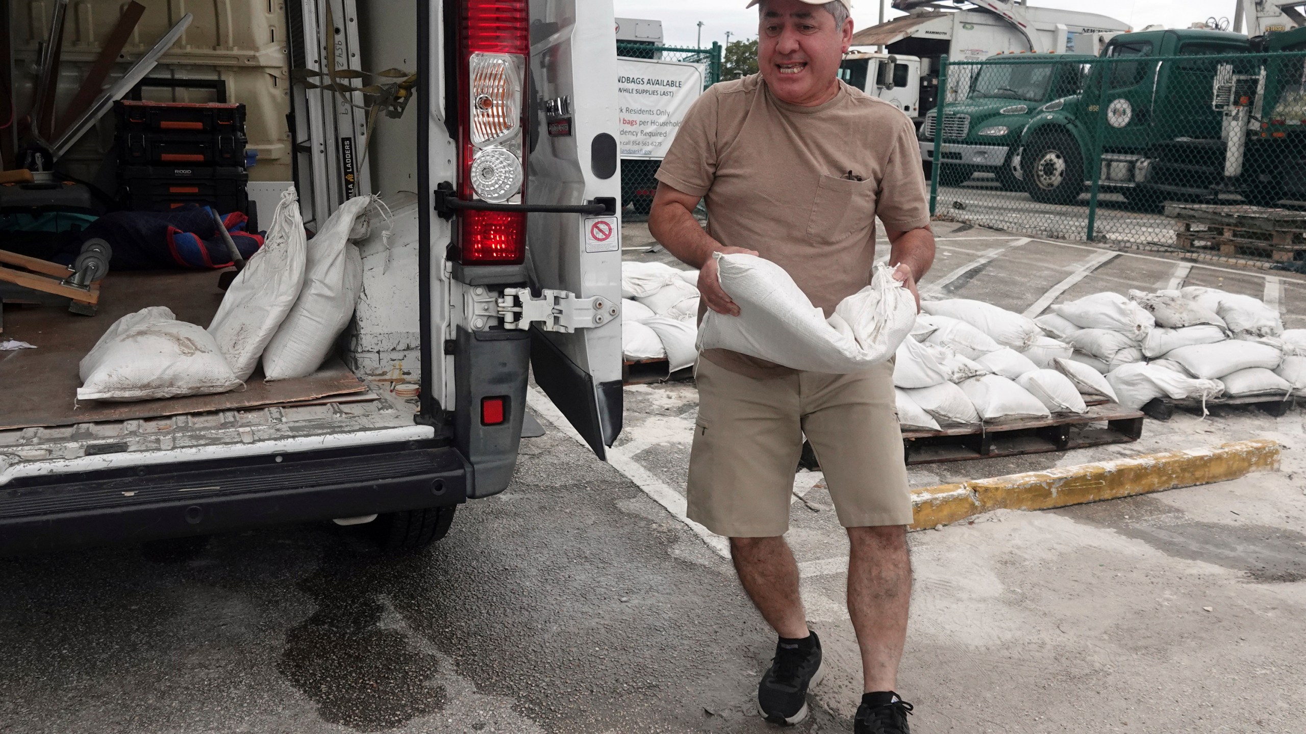 Nelson Hoyos loads sandbags for his business in Oakland Park, Fla., Sunday, Oct. 6, 2024, as Florida is in for a wet week as the storm nears the west coast. (Joe Cavaretta/South Florida Sun-Sentinel via AP)