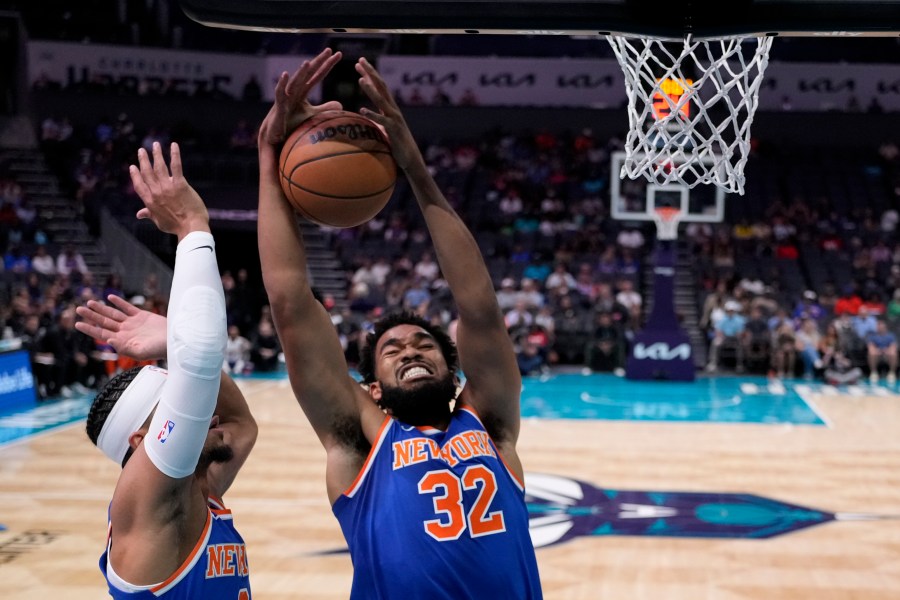 New York Knicks center Karl-Anthony Towns pulls down a rebound as guard Josh Hart looks on during the first half of a preseason NBA basketball game against the Charlotte Hornets, Sunday, Oct. 6, 2024, in Charlotte, N.C. (AP Photo/Chris Carlson)