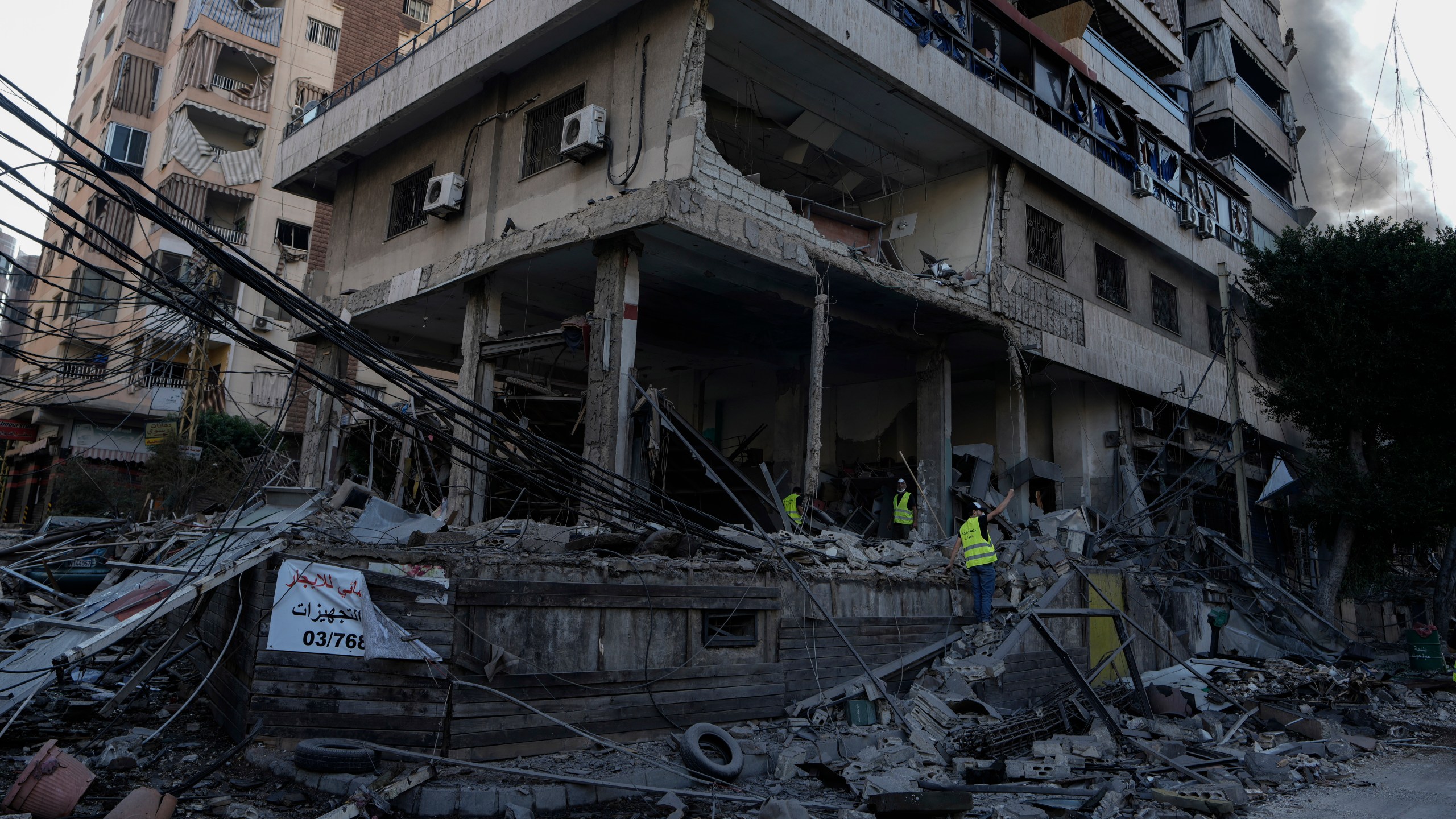 Emergency workers inspect a building that was hit in an Israeli airstrike in Dahiyeh, Beirut, Lebanon, Sunday, Oct. 6, 2024. (AP Photo/Bilal Hussein)