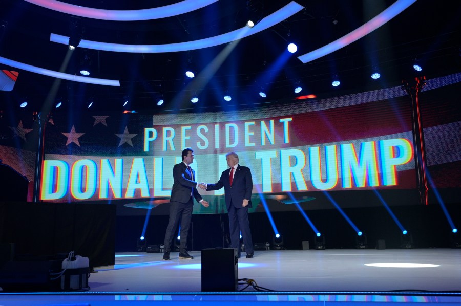 FILE - Former President Donald Trump, right, shakes hands with Turning Point CEO Charlie Kirk before speaking during the Turning Point USA Student Action Summit, Saturday, July 23, 2022, in Tampa, Fla. (AP Photo/Phelan M. Ebenhack, File)