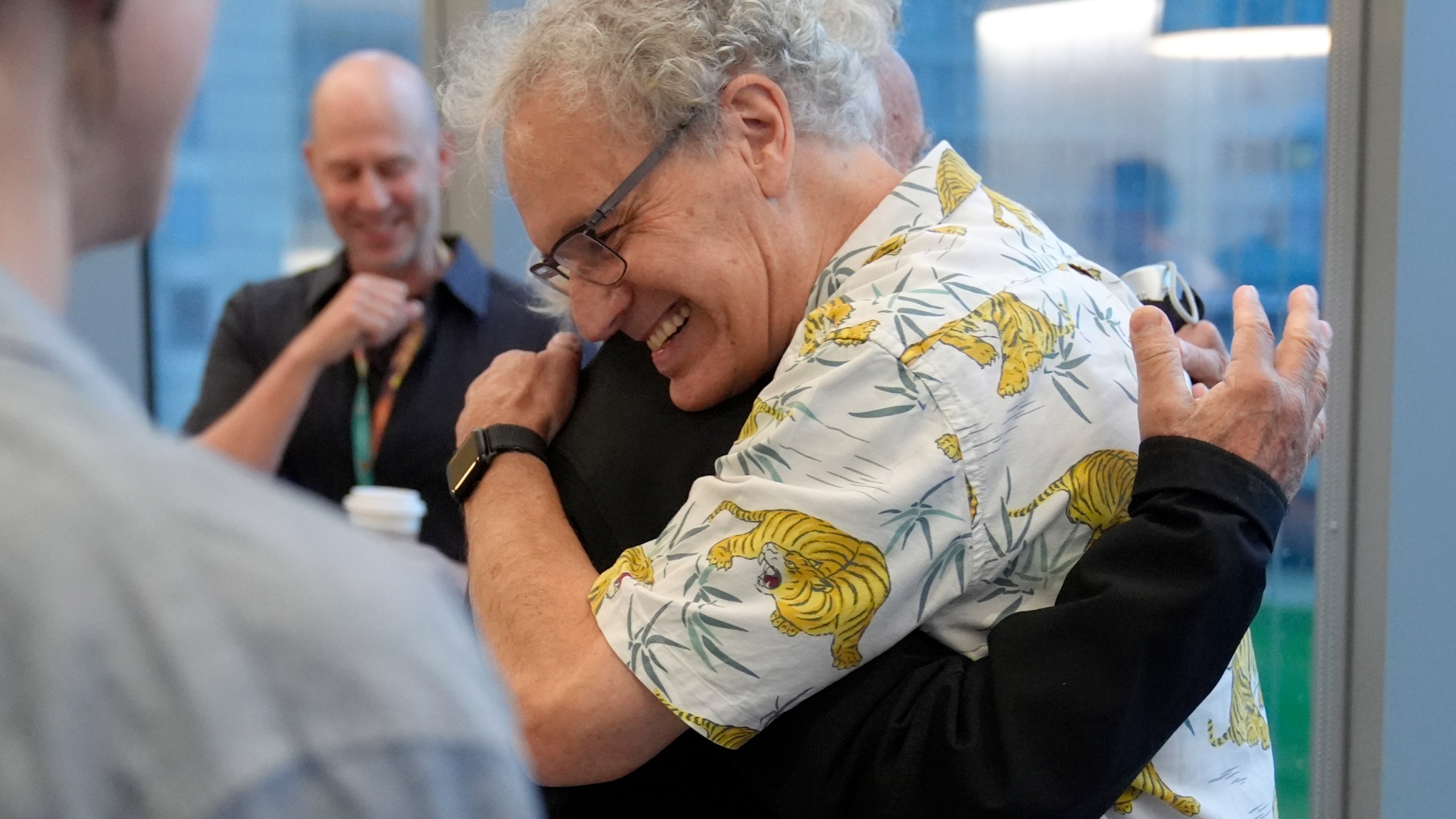 Victor Ambros, 2024 Nobel Prize winner in physiology or medicine, and professor of natural science at the University of Massachusetts Medical School, right, hugs collegue Allan Jacobson, at the school, in Worcester, Mass. Monday, Oct. 7, 2024. (AP Photo/Steven Senne)