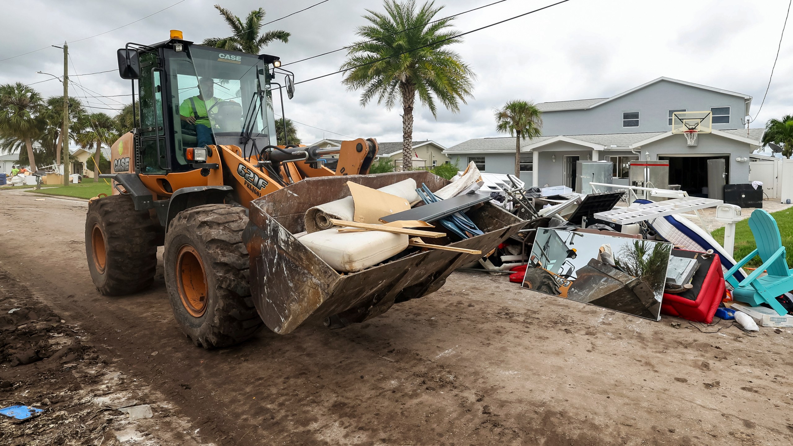 Contractors with the City of New Port Richey help clean debris left by Hurricane Helene in preparation for Hurricane Milton on Monday, Oct. 7, 2024, in New Port Richey, Fla. (AP Photo/Mike Carlson)