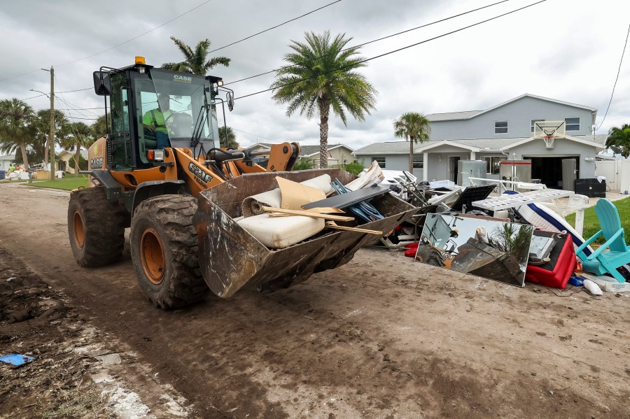 Contractors with the City of New Port Richey help clean debris left by Hurricane Helene in preparation for Hurricane Milton on Monday, Oct. 7, 2024, in New Port Richey, Fla. (AP Photo/Mike Carlson)