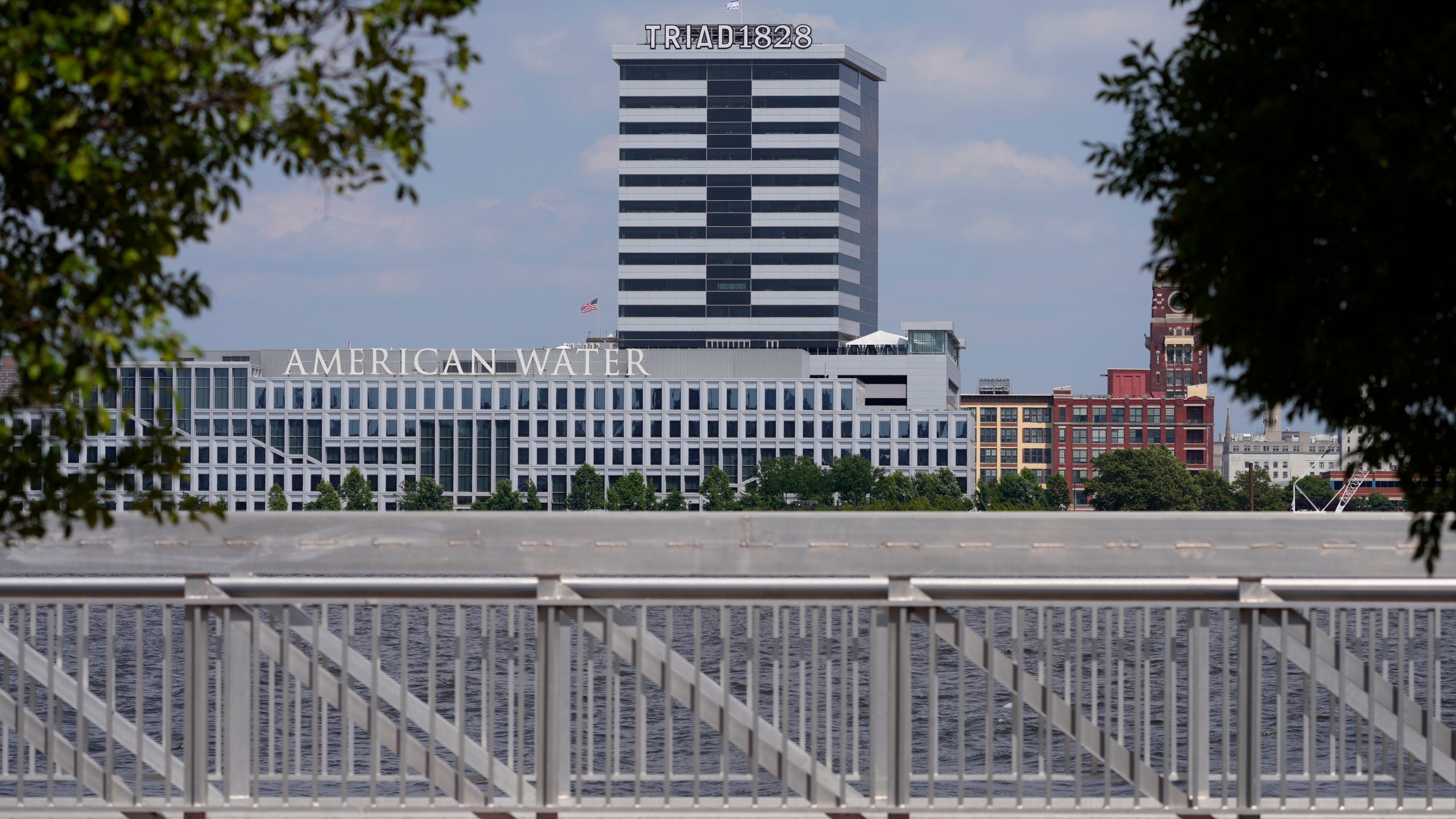 FILE - The largest regulated water and wastewater utility company in the U.S., American Water, its building in Camden, N.J., seen in the foreground on June 17, 2024, says it was the victim of a cyberattack, prompting the firm to pause billing to customers. (AP Photo/Matt Slocum, File)