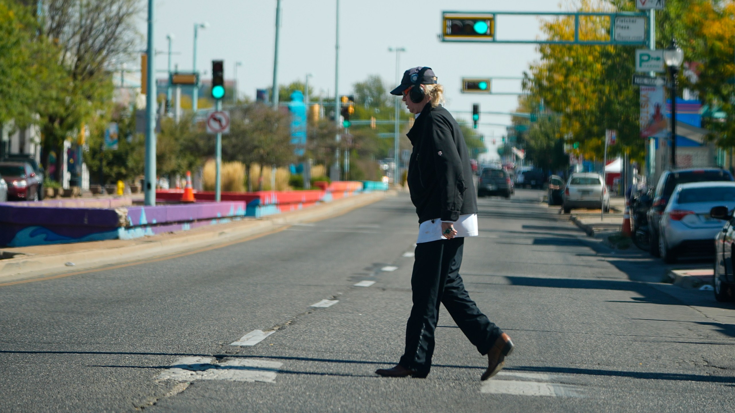 A lone pedestrian crosses East Colfax Avenue at the intersection with Dayton Street, Wednesday, Oct. 9, 2024, in the east Denver suburb of Aurora, Colo. (AP Photo/David Zalubowski)