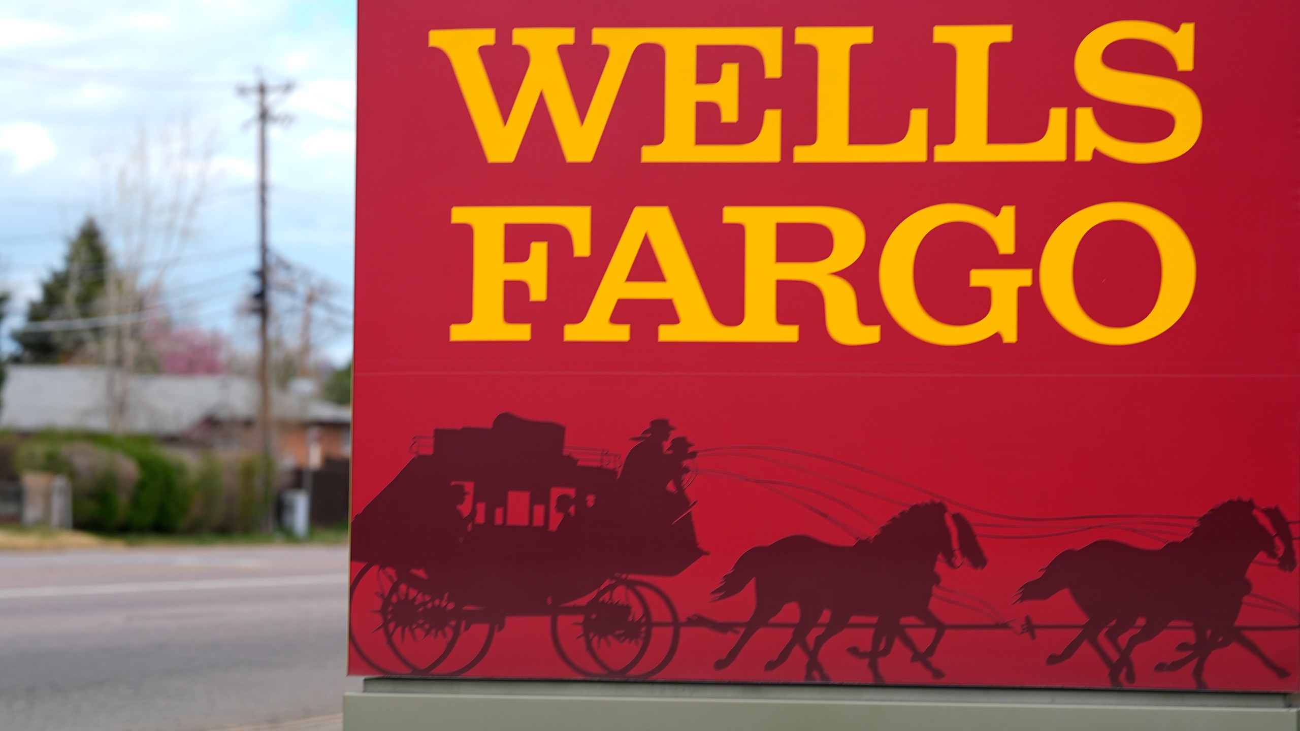 FILE - A sign stands outside a branch of Wells Fargo bank on April 17, 2024, in Littleton, Colo. (AP Photo/David Zalubowski, File)