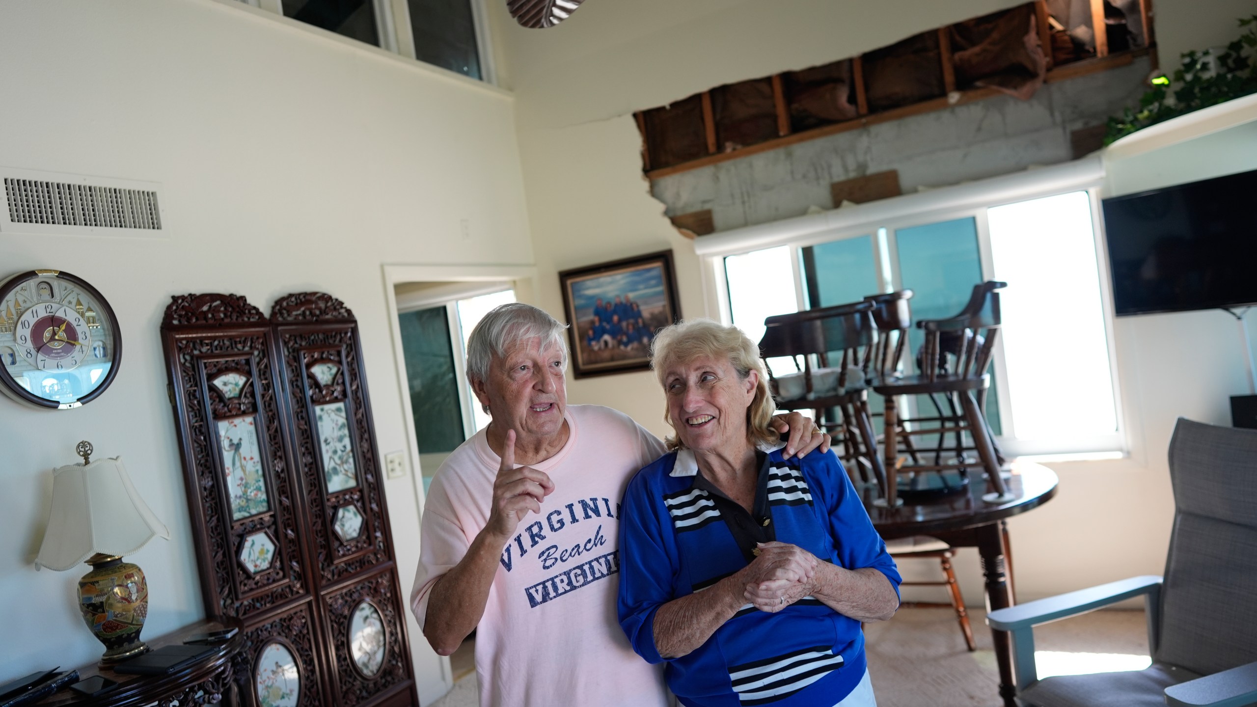 Ron and Jean Dyer, high school sweethearts who have been married for 60 years, talk in the living room of their second-floor beachfront condominium, which lost its roof and a section of wall during Hurricane Milton, in Venice, Fla., Saturday, Oct. 12, 2024. (AP Photo/Rebecca Blackwell)