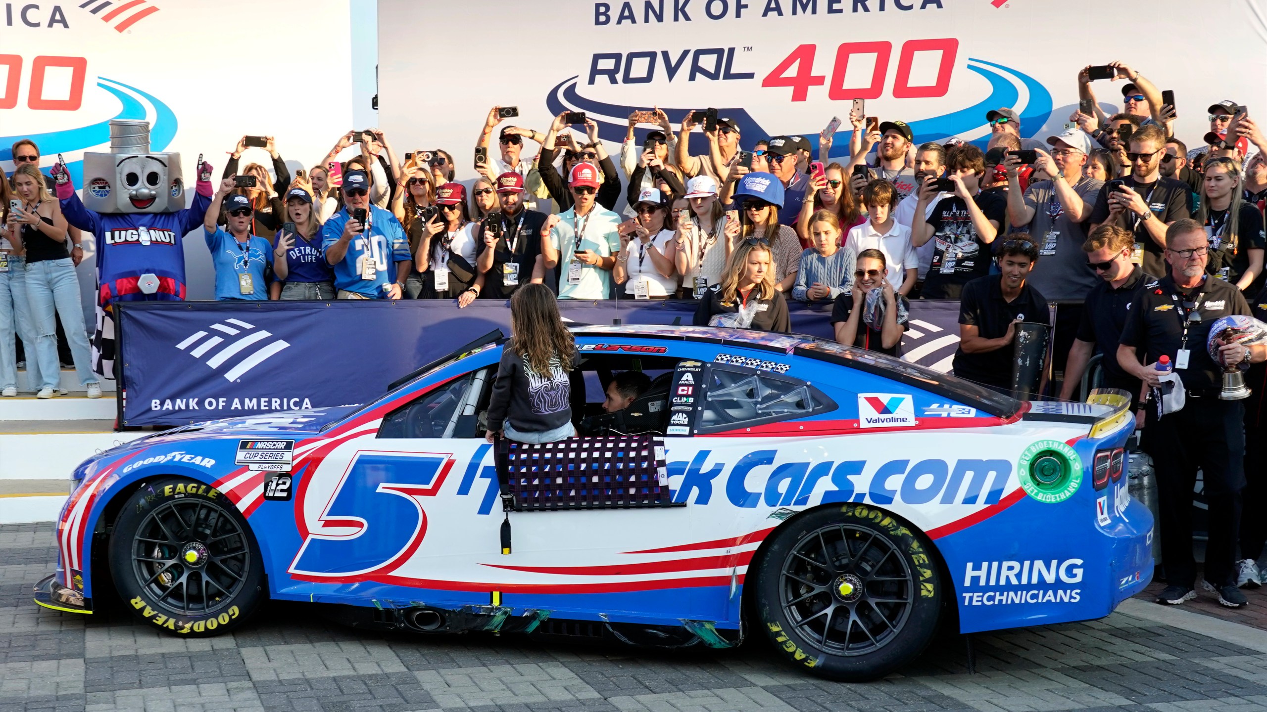 Kyle Larson drives into Victory Lane with his daughter Audrey, 6, after winning a NASCAR Cup Series auto race at Charlotte Motor Speedway in Concord, N.C., Sunday, Oct. 13, 2024. (AP Photo/Chuck Burton)