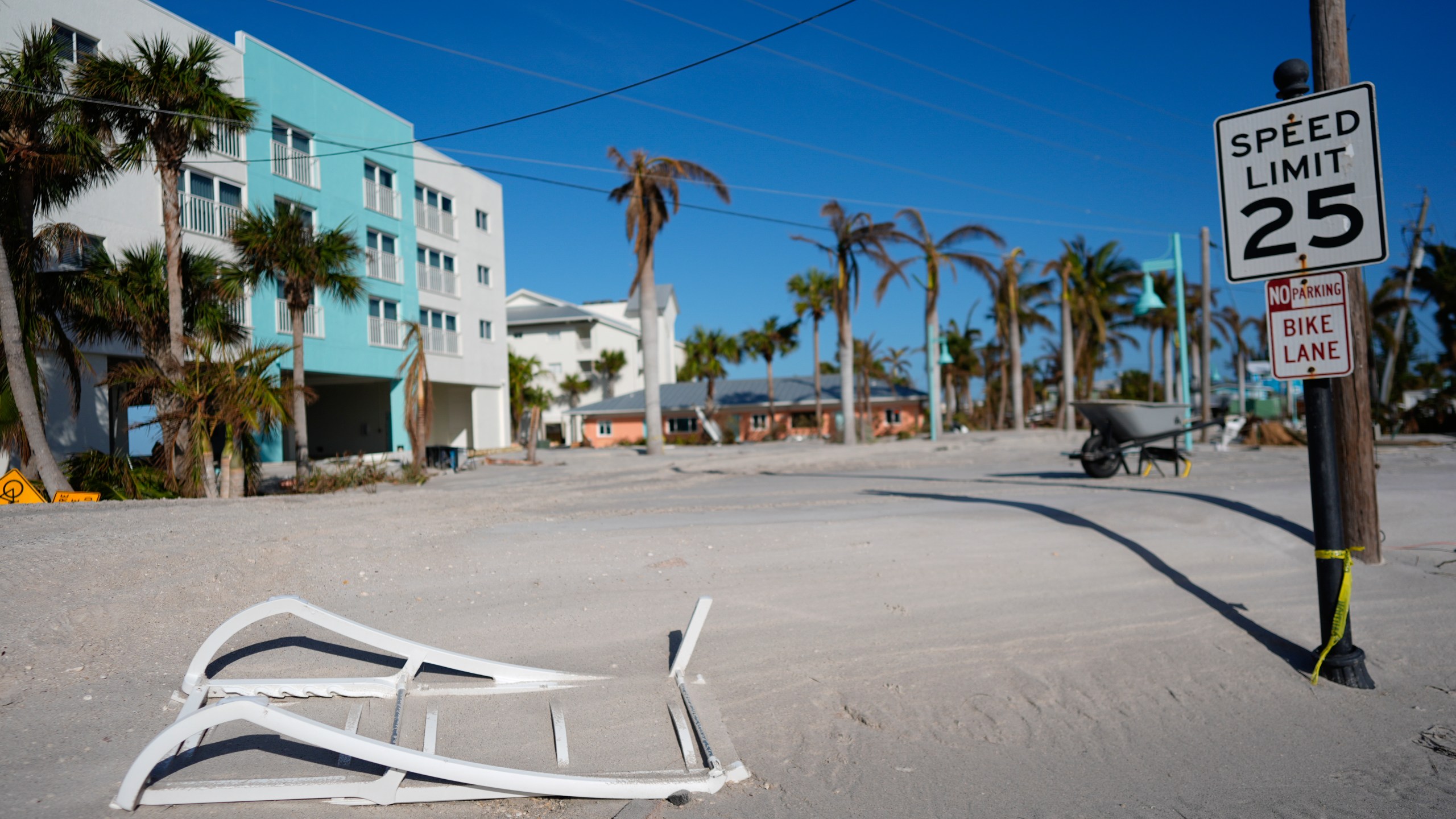 Sand covers a remaining stretch of the main road in southern Manasota Key, in Englewood, Fla., as Charlotte County crews work to clear it, following the passage of Hurricane Milton, Sunday, Oct. 13, 2024. (AP Photo/Rebecca Blackwell)