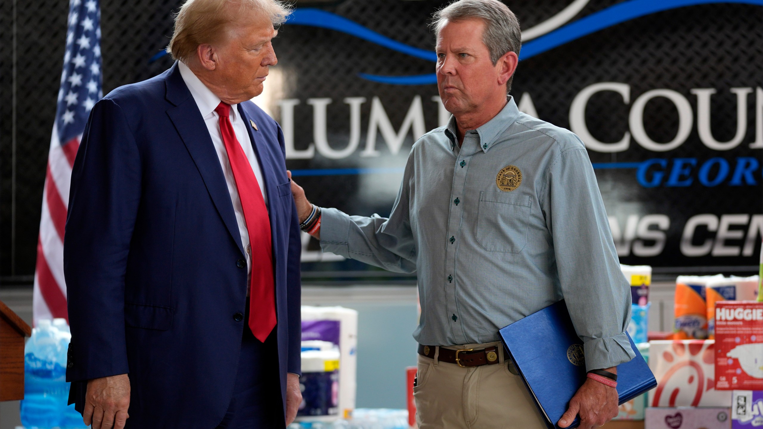 Republican presidential nominee former President Donald Trump is joined by Georgia Gov. Brian Kemp at a temporary relief shelter as he visits areas impacted by Hurricane Helene, Friday, Oct. 4, 2024, in Evans, Ga. (AP Photo/Evan Vucci)