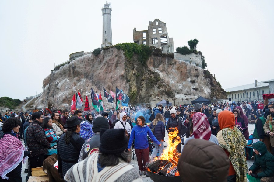 People attending the Indigenous Peoples Day Sunrise Gathering offer tobacco to the fire on Monday, Oct. 14, 2024, in San Francisco. (AP Photo/Minh Connors)