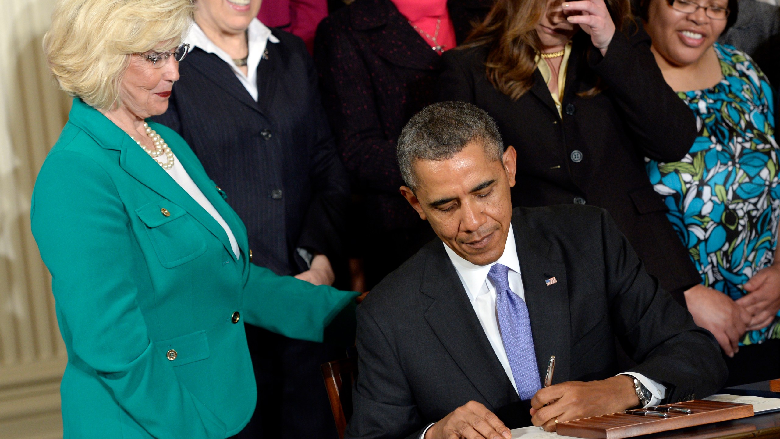 FILE - Lilly Ledbetter watches as President Barack Obama signs executive actions, with pending Senate legislation, aimed at closing a compensation gender gap that favors men, at the White House in Washington, April 8, 2014, during an event marking Equal Pay Day. (AP Photo/Susan Walsh, File)