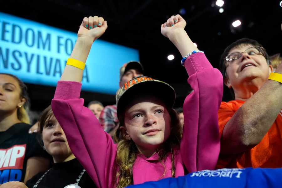 A young attendee cheers as Democratic presidential nominee Vice President Kamala Harris speaks during a campaign rally at Erie Insurance Arena, in Erie, Pa., Monday, Oct. 14, 2024. (AP Photo/Jacquelyn Martin)