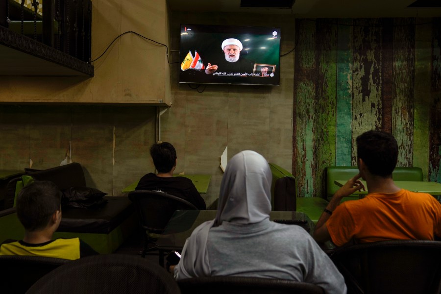 People listen to a speech by Naim Kassem, acting leader of Hezbollah, broadcasted on a television channel, at a coffee shop in Beirut, Lebanon, Tuesday, Oct. 15, 2024. (AP Photo/Bilal Hussein)