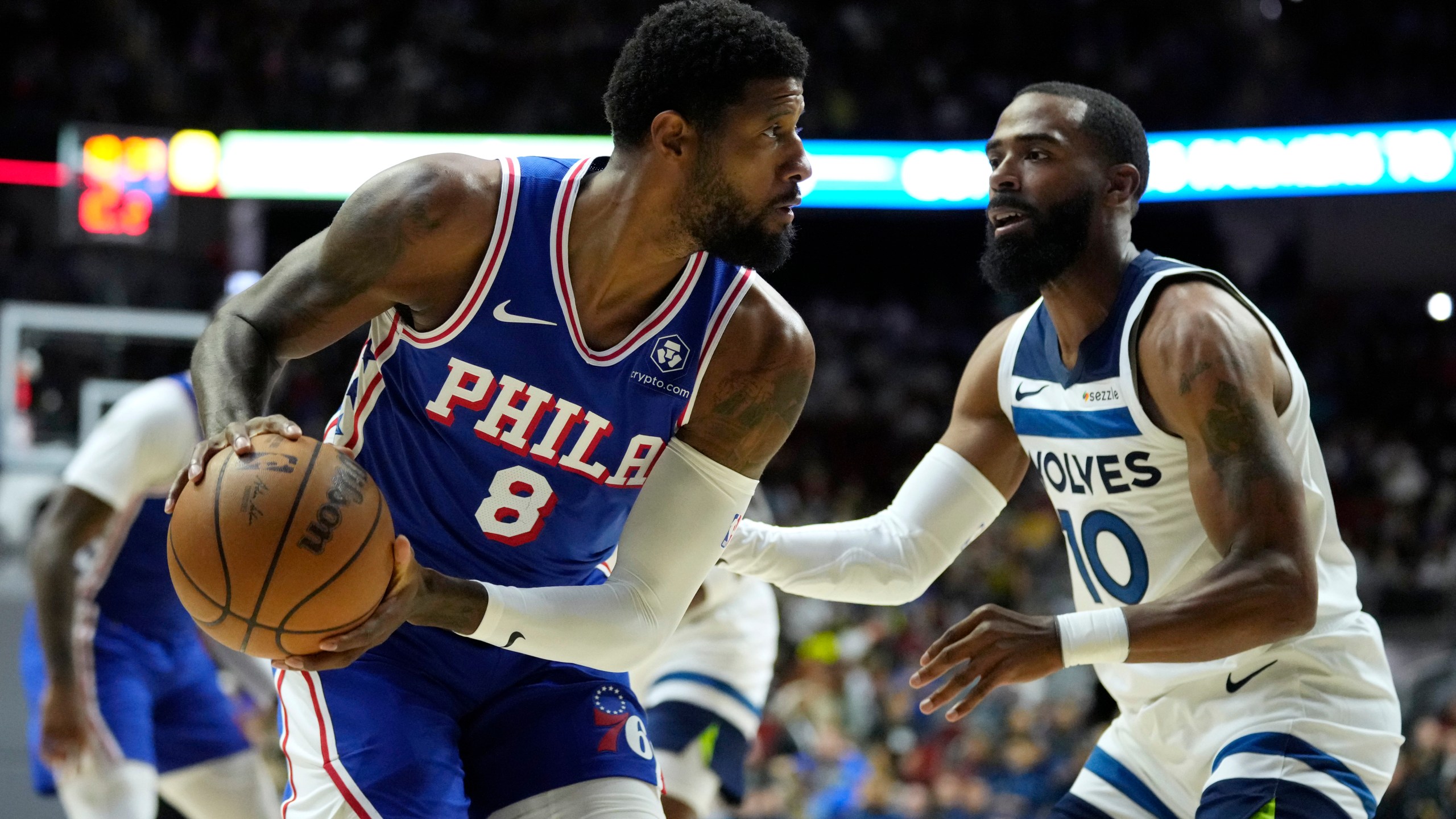 Philadelphia 76ers forward Paul George (8) looks to drive around Minnesota Timberwolves guard Mike Conley (10) during the first half of an NBA preseason basketball game, Friday, Oct. 11, 2024, in Des Moines, Iowa. (AP Photo/Charlie Neibergall)