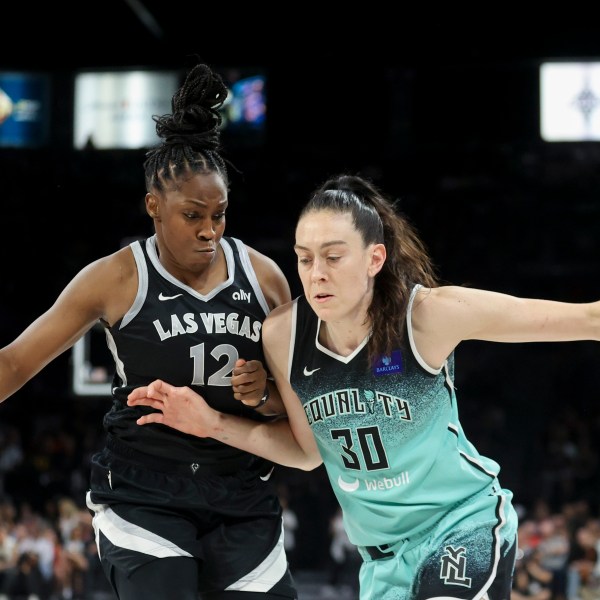 New York Liberty forward Breanna Stewart (30) drives past Las Vegas Aces guard Chelsea Gray (12) during the second half of a WNBA Semifinal basketball game, Sunday, Oct. 6, 2024, in Las Vegas. (AP Photo/Ian Maule)