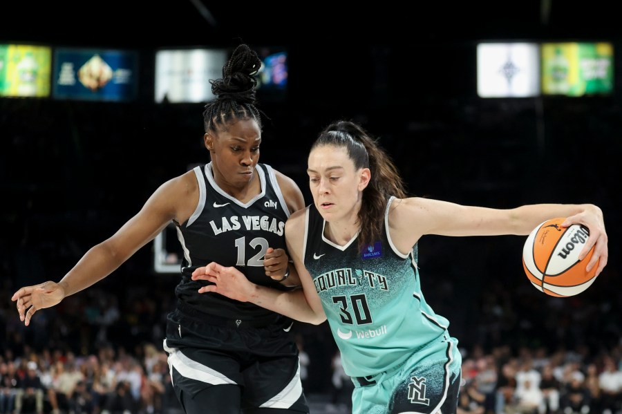 New York Liberty forward Breanna Stewart (30) drives past Las Vegas Aces guard Chelsea Gray (12) during the second half of a WNBA Semifinal basketball game, Sunday, Oct. 6, 2024, in Las Vegas. (AP Photo/Ian Maule)