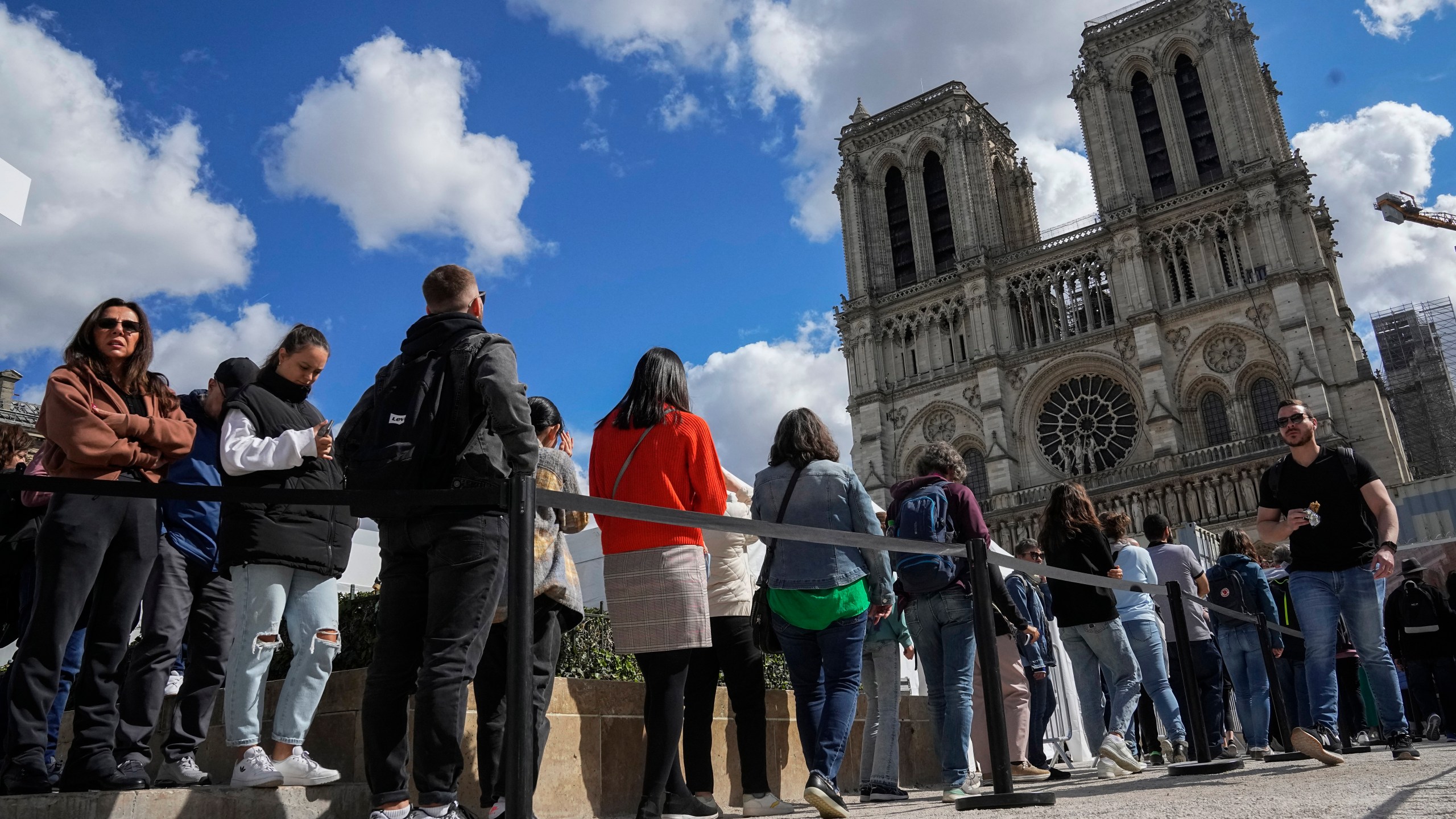 FILE - People line up to have a close look of Notre Dame cathedral as they visit the rebuilding site during Heritage Day in Paris, Sept. 17, 2022. (AP Photo/Michel Euler, File)