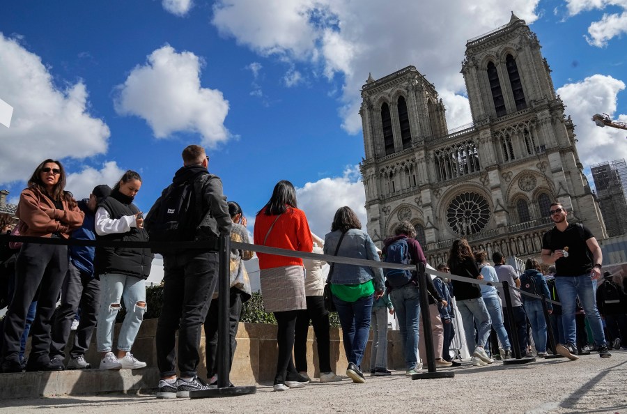 FILE - People line up to have a close look of Notre Dame cathedral as they visit the rebuilding site during Heritage Day in Paris, Sept. 17, 2022. (AP Photo/Michel Euler, File)