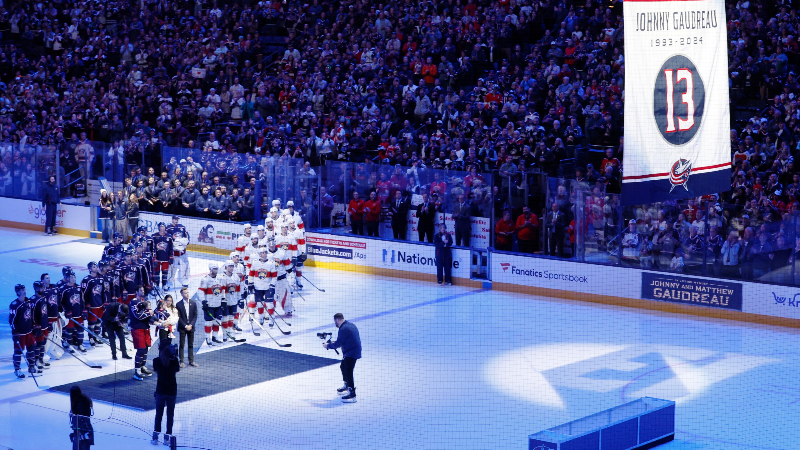 Blue Jackets' Johnny Gaudreau's family watches a #13 banner being raised during a ceremony before the start of an NHL hockey game between the Columbus Blue Jackets and the Florida Panthers. Tuesday, Oct. 15, 2024, in Columbus, Ohio. (AP Photo/Jay LaPrete)